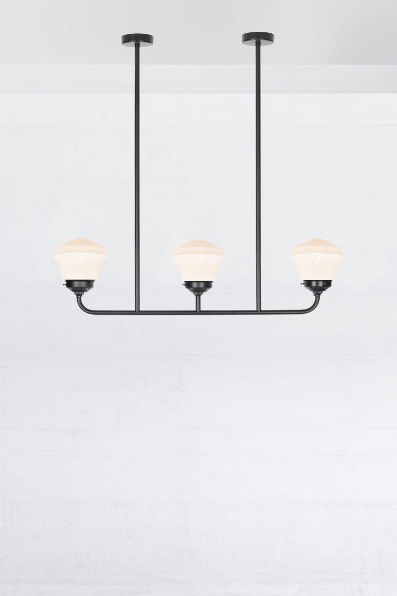 Black 3 light linear chandelier with black galleries and opal schoolhose shades. 