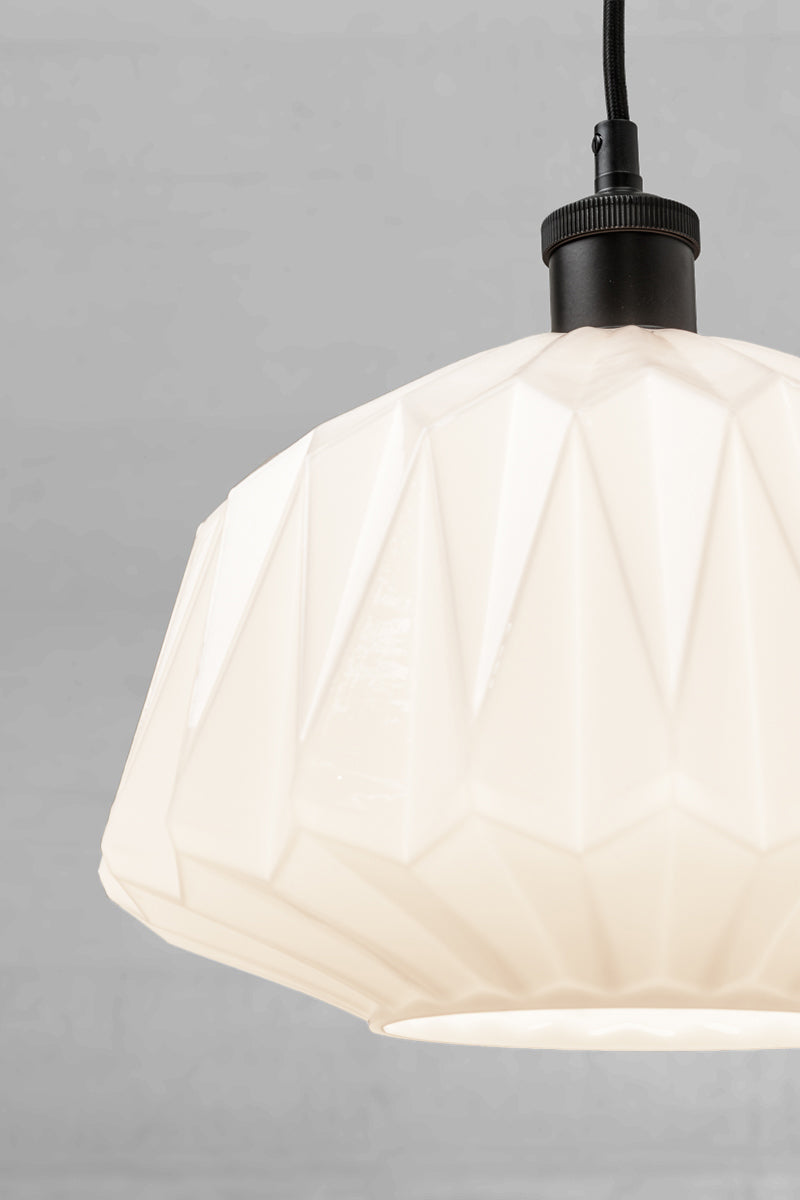 Close  up of the opal geometric shade with a black lampholder and cord. 