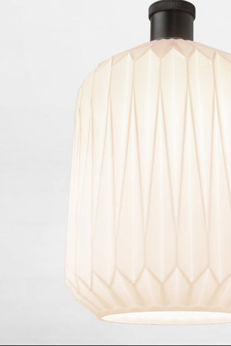 Close up of the opal shade with geometric design on a black lampholder.