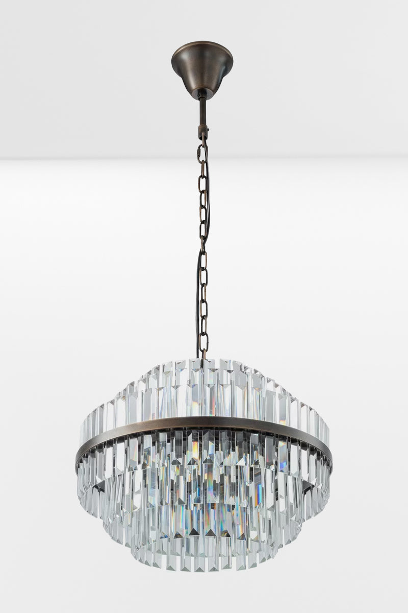 Medium glass chandelier with antique brass metalwear and three tiers and lights off.