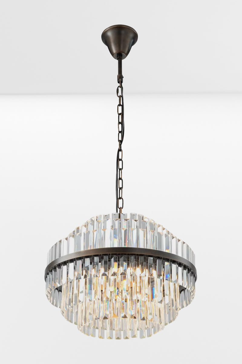 Angled view of the medium glass chandelier with antique brass metalwear and three tiers. 