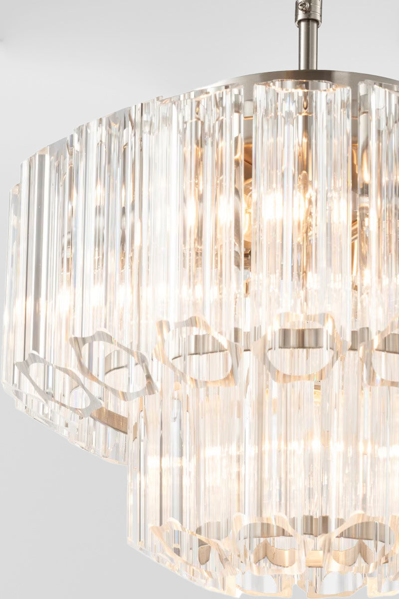 Close up of the small glass chandelier with chrome finished metalware and lights on.