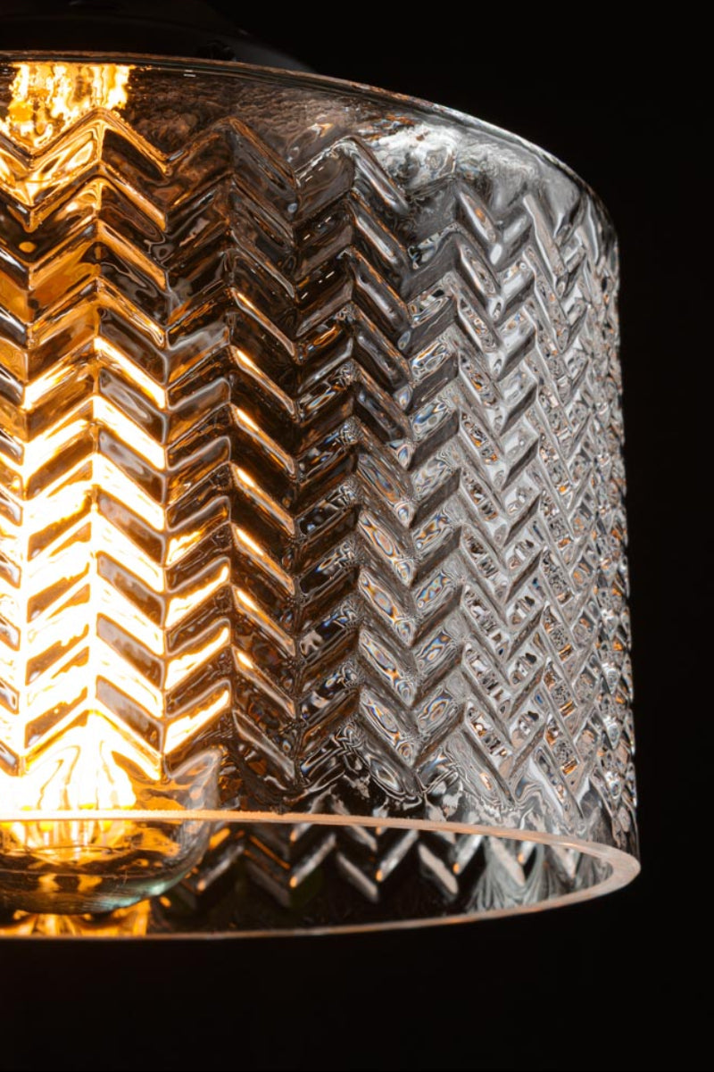 Close up of the chevron patterned glass of the Malibu shade, illuminated in a dark room. 