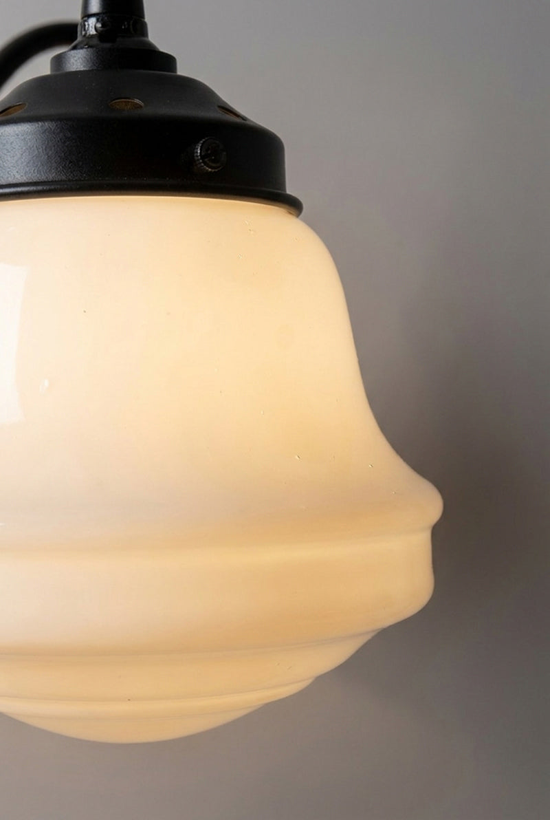 Close-up of the Colton Schoolhouse opal glass shade with sculpted curves and black metal gallery.