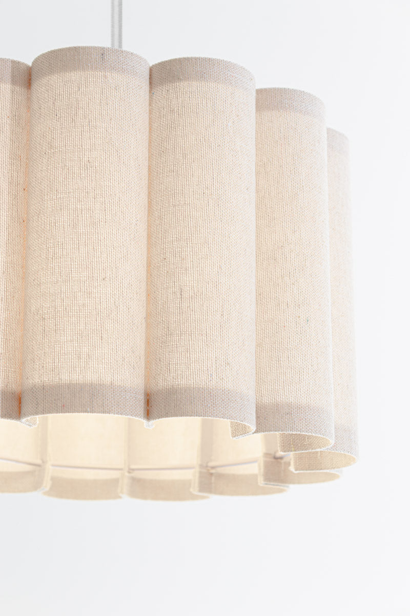 Close up of the beige/ neutral coloured fabric shade with a scalloped silhouette.