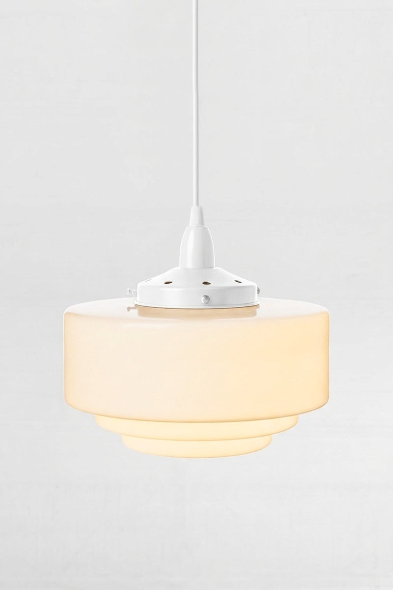 Stepped detailing of the opal schoolhouse shade with stepped detailing and a white pendant cord. 