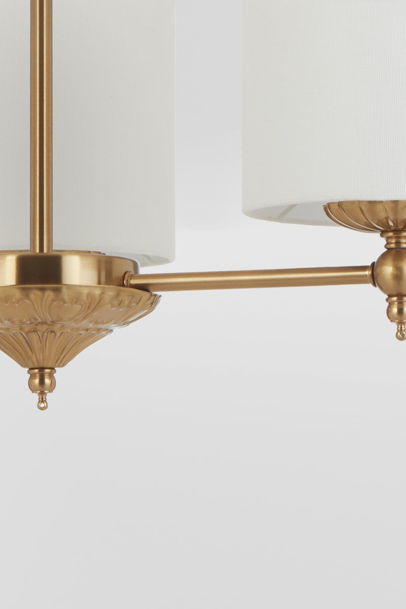 Close up of the frame of the 3 light antique gold chandelier with ivory satin shades