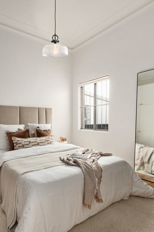 Large clear holophane shade on black pendant cord as a bedroom light. 
