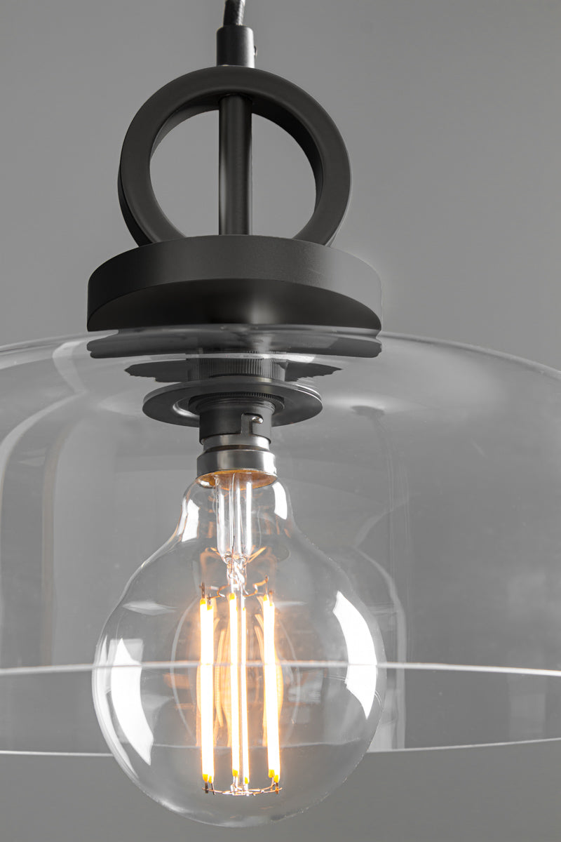 Close-up of the Dixon NYC Glass Pendant Light highlighting the matt black ring and disc suspension, clear glass shade and decorative filament bulb.