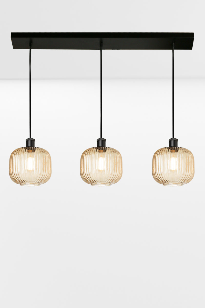 3 light linear multi pendant light with amber reeded open glass shades in an even row. 