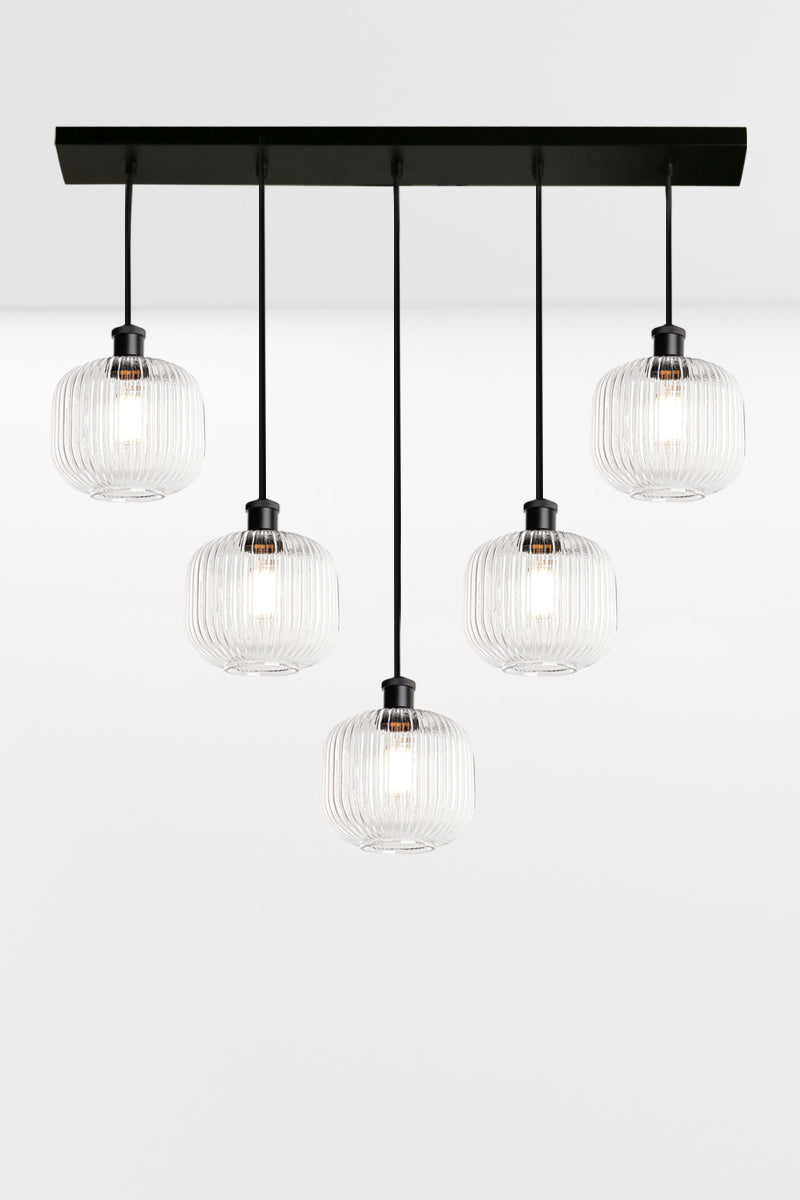 5 light linear multi pendant light with clear reeded open glass shades in a 'V' formation. 