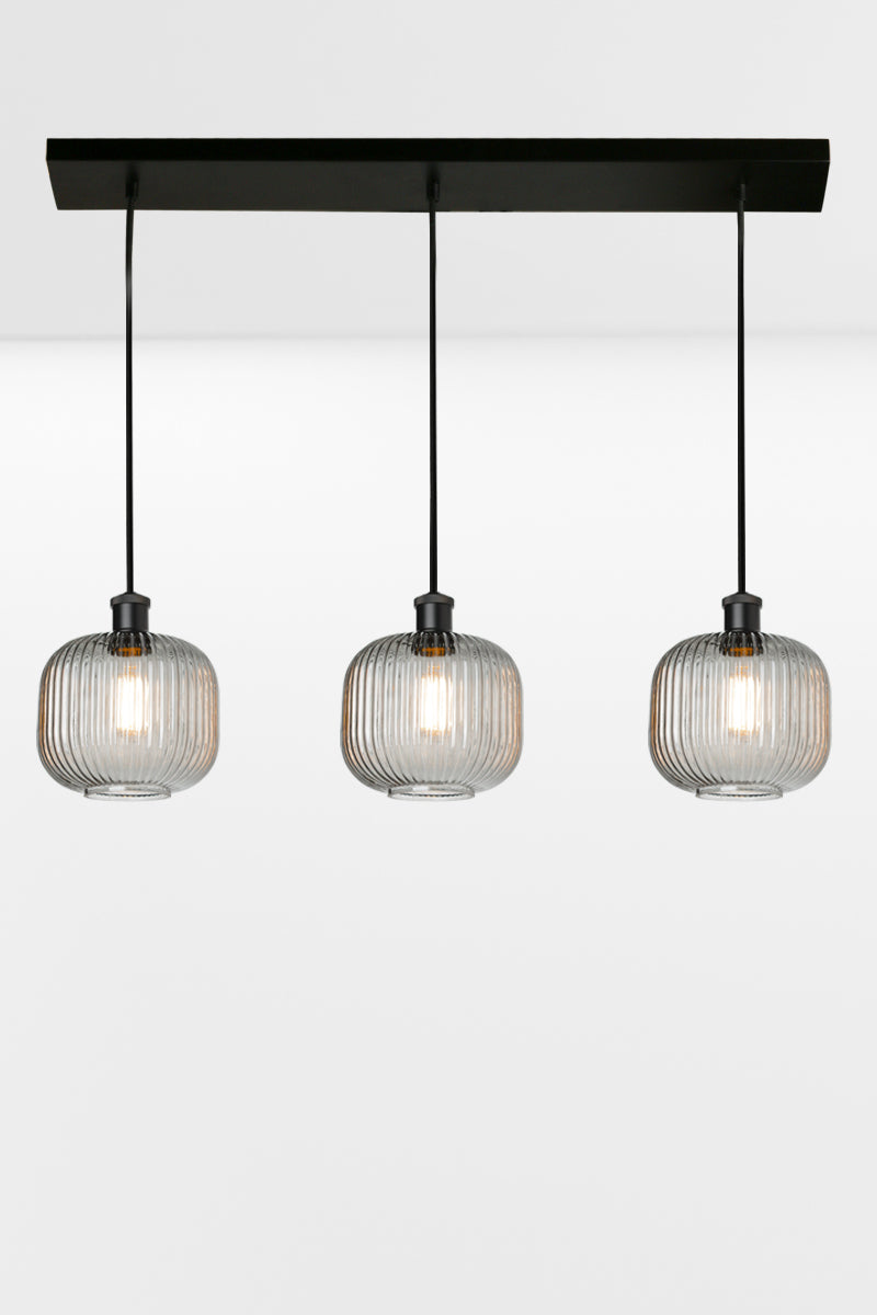 3 light linear multi pendant light with grey reeded open glass shades in an even row. 