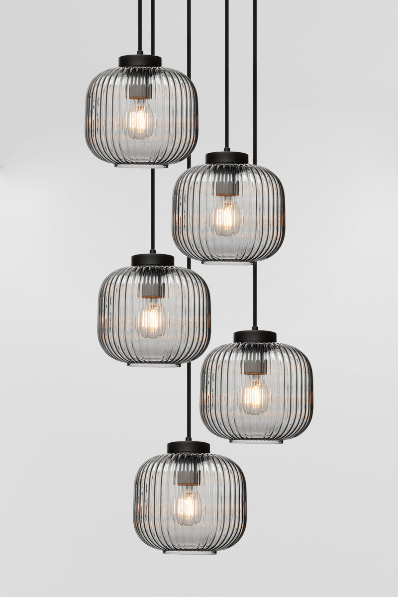 Five drop pendant light with reeded glass shades in grey and paired with black hardware. 