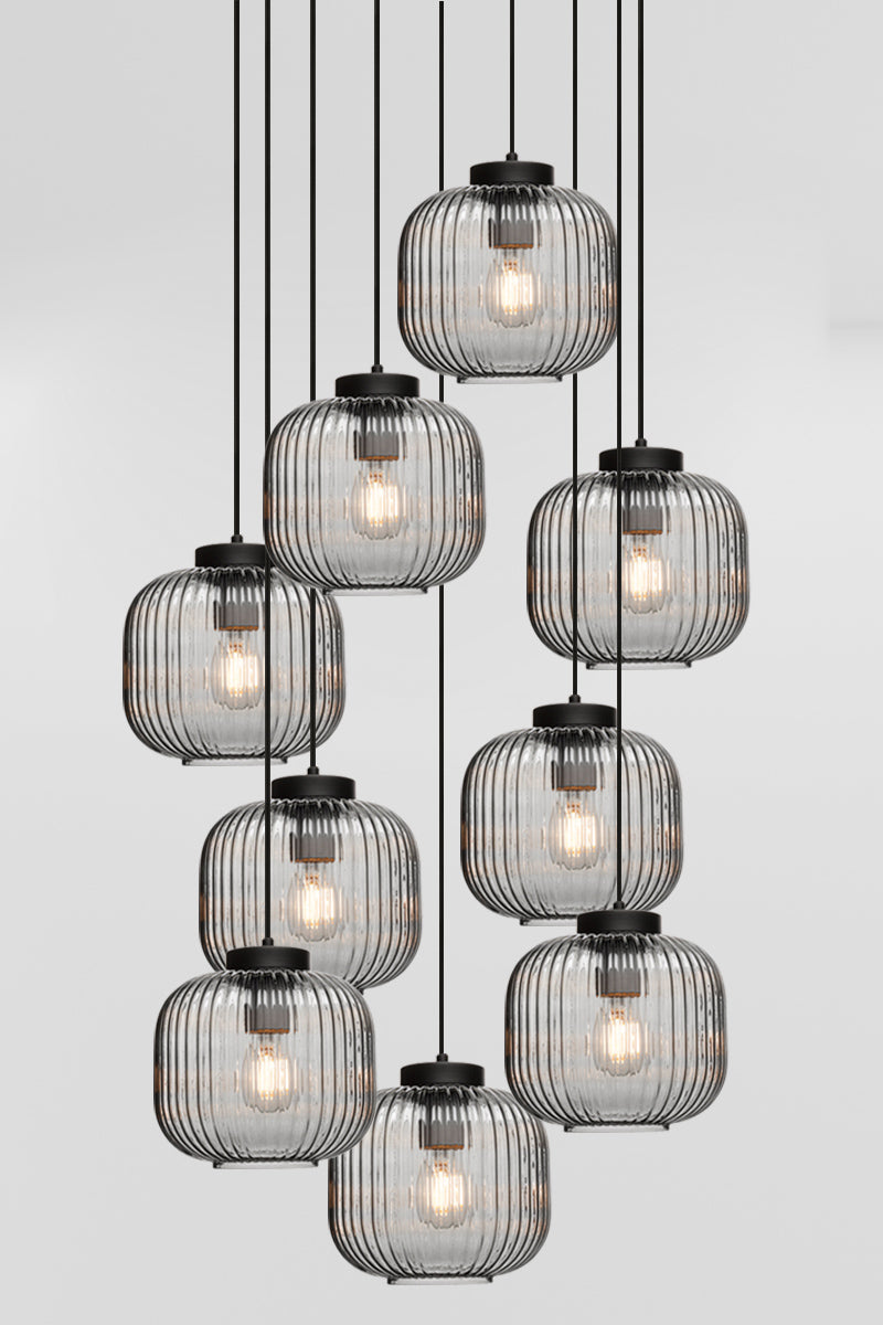 Nine drop pendant light with reeded glass shades in grey, paired with black hardware. 