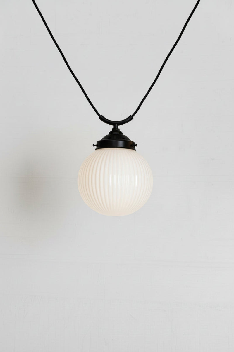 Reeded opal glass shade on a black trapeze fixture