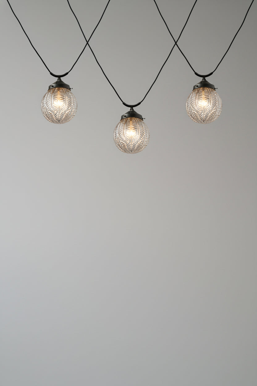 Three macleay glass shades on trapeze pendant cords as an installation. 