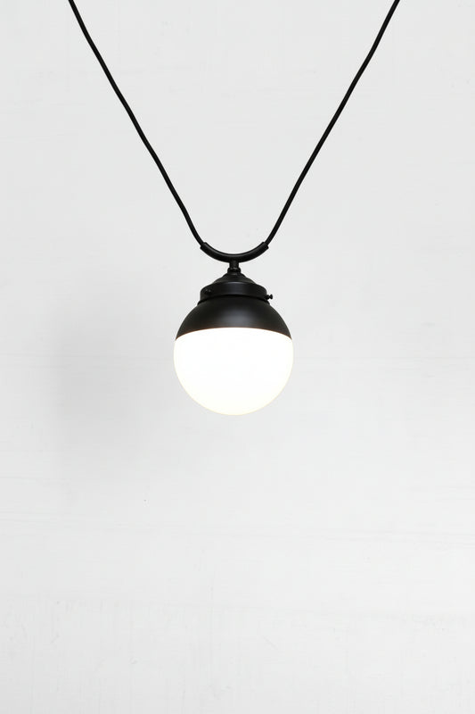 glass ball shades shown on a black trapeze pendant cord. 
