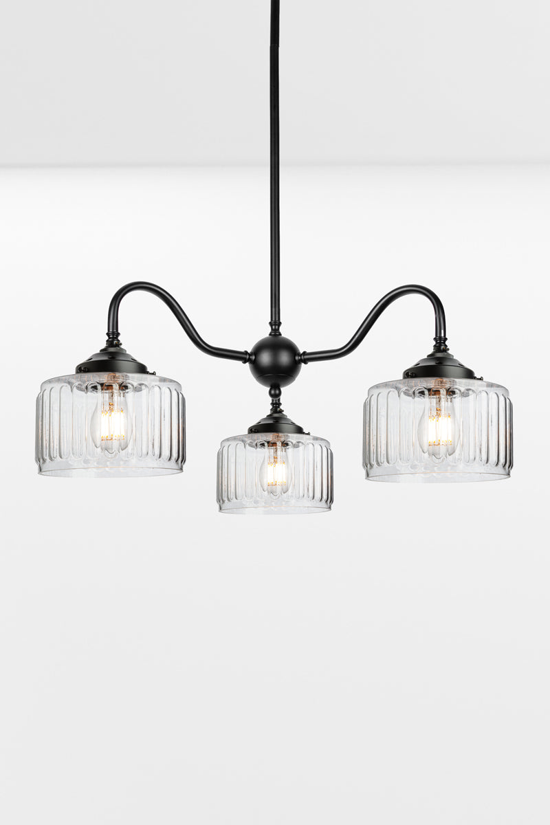 Black three arm gooseneck chandelier with  three Capri Clear glass shades featuring fluted detailing.