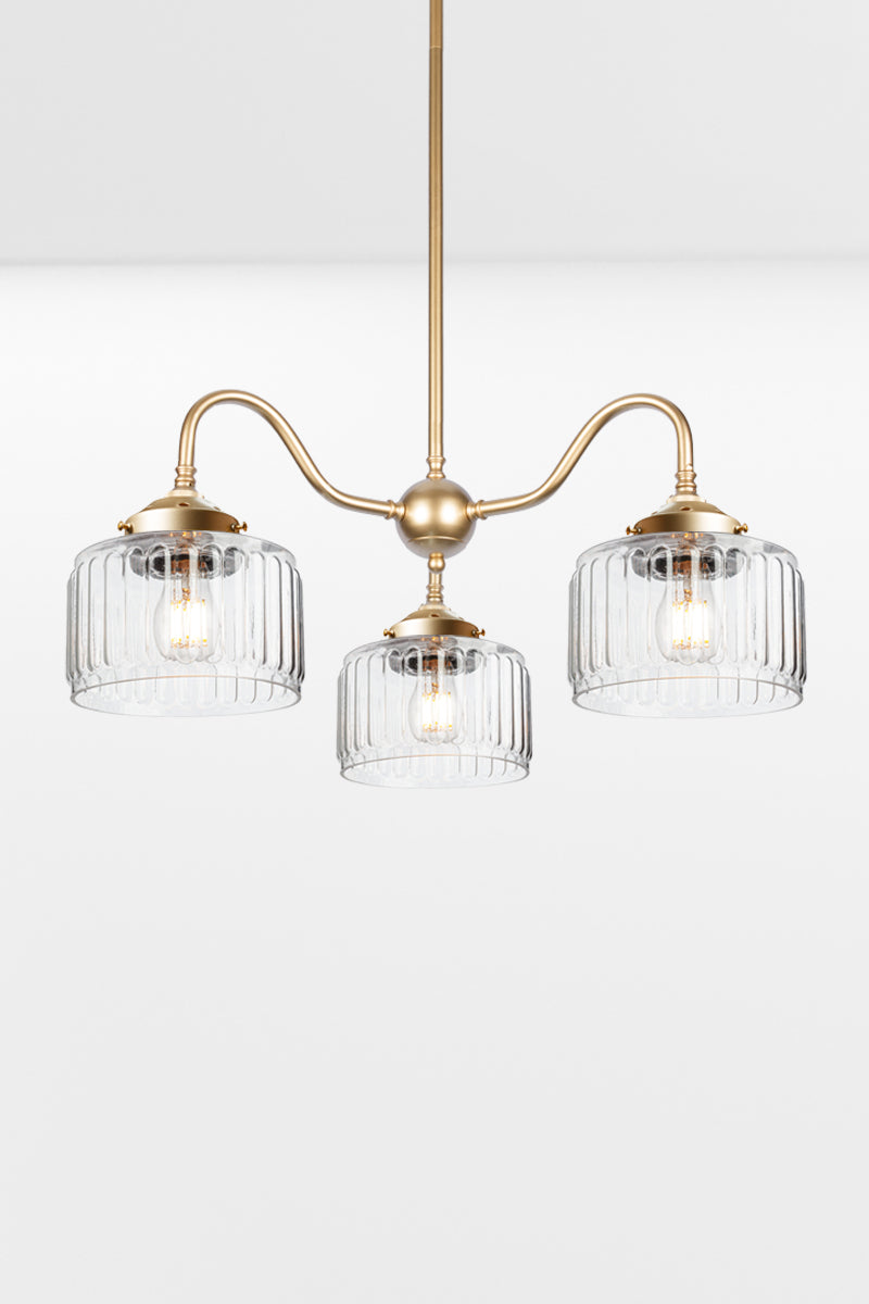 Gold/brass three arm gooseneck chandelier with  three Capri Clear glass shades featuring fluted detailing.