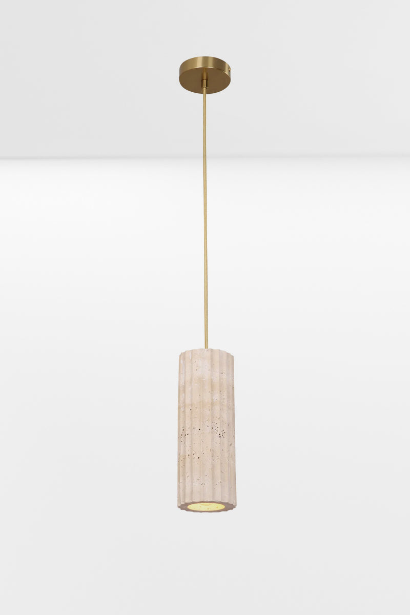Oblong travertine pendant light with subtle fluting across the natural finish, paired with gold fabric cord and gold hardware. 