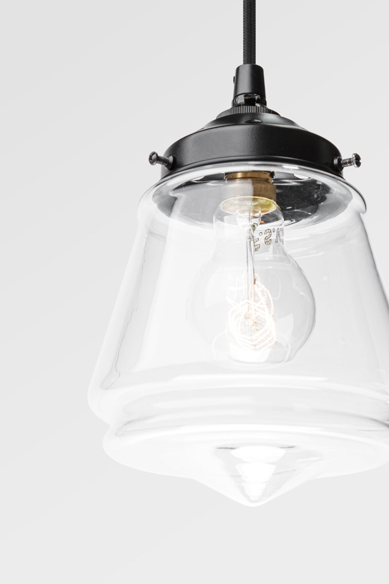 Close up of the clear glass Mae Deco Glass Shade paired with a black gallery and cloth cord. 