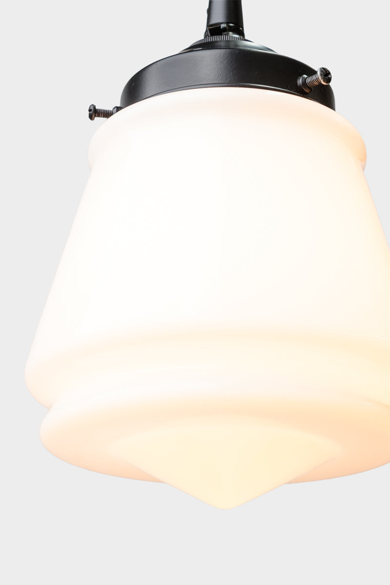 Close up of the opal glass Mae Deco Glass Shade paired with a black gallery and cloth cord. 