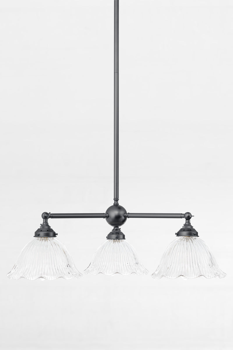 Black 3 arm chandelier with adjustable lampholders, paired with reeded clear glass shades with a frilled edge
