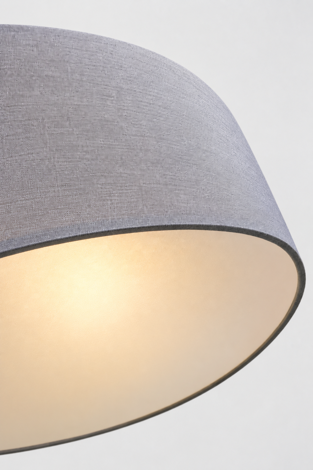 Close-up of the underneith of the grey fabric drum shade on the Clemente pendant light highlighting the woven fabric texture.