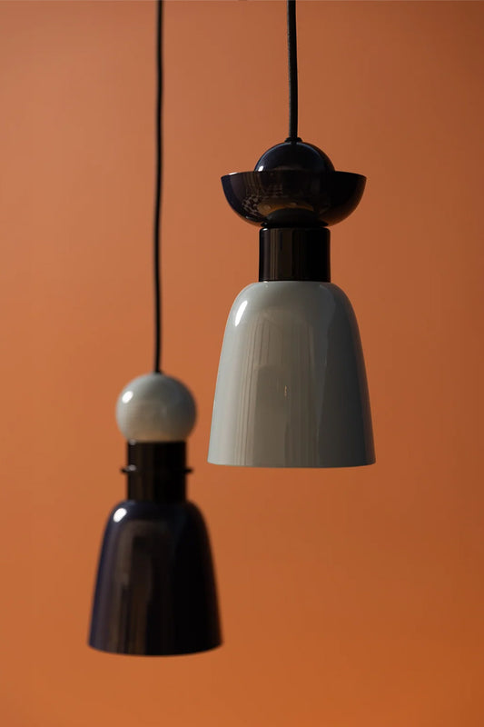 Putnam Pendant Light Style A and Style B suspended together against a warm terracotta background