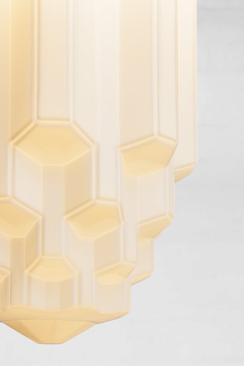 The glass form cascades down three distinct horizontal tiers with hexagonal detailing visible on the lower tiers. This adds depth and geometric complexity that is the signature of artisanal quality
