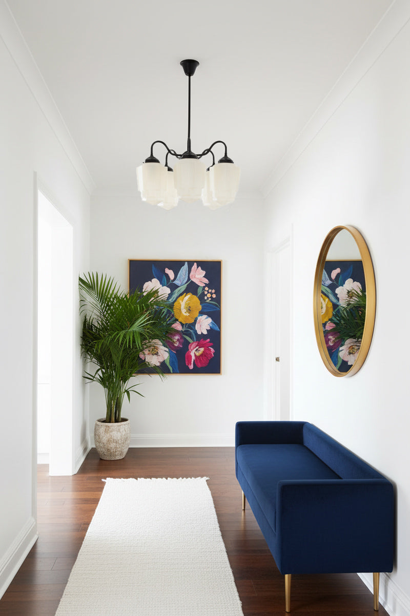 Five gooseneck arm pendant light in black with five large opal glass shades with an Art Deco influence, installed in a bright, contemporary hallway.