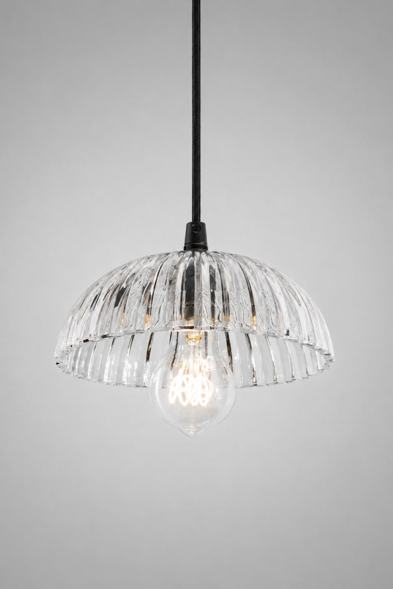 Deloraine clear glass pendant light illuminated to showcase soft light refraction through the ridged pressed glass shade.