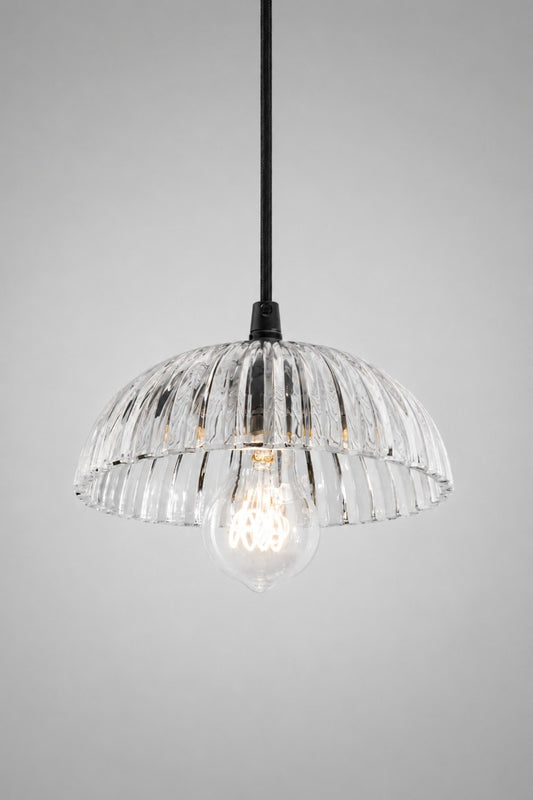Deloraine clear glass pendant light illuminated to showcase soft light refraction through the ridged pressed glass shade.