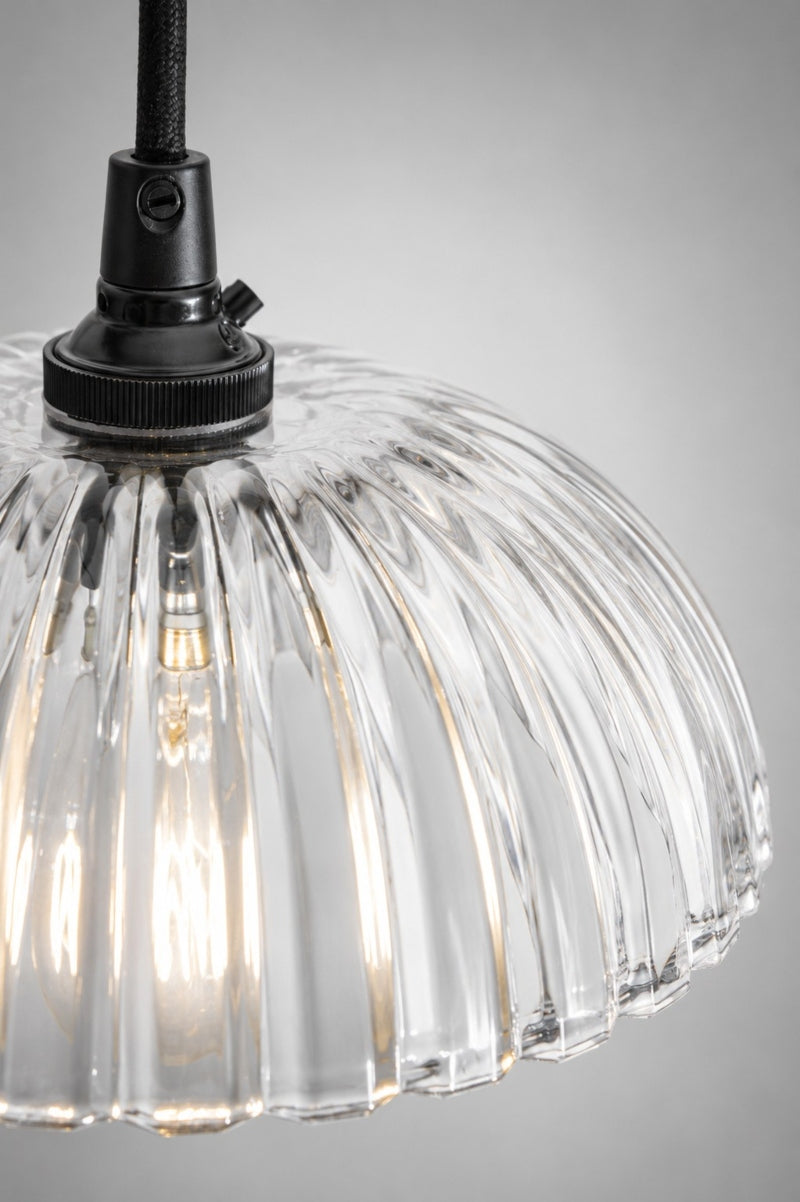 Close up detail of the Deloraine pendant light showing the ridged clear pressed glass shade and black lampholder.