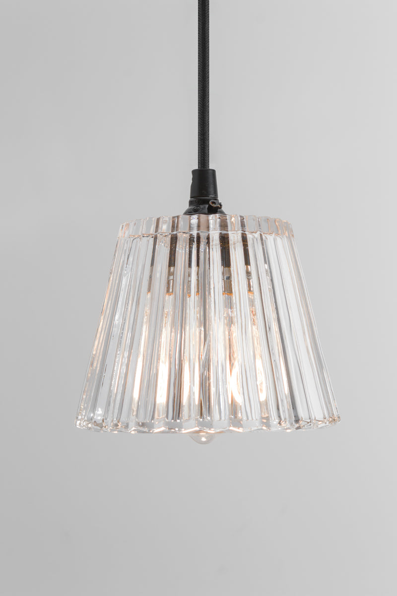 Clear fluted glass pendant light. Compact, tapered design for smaller spaces