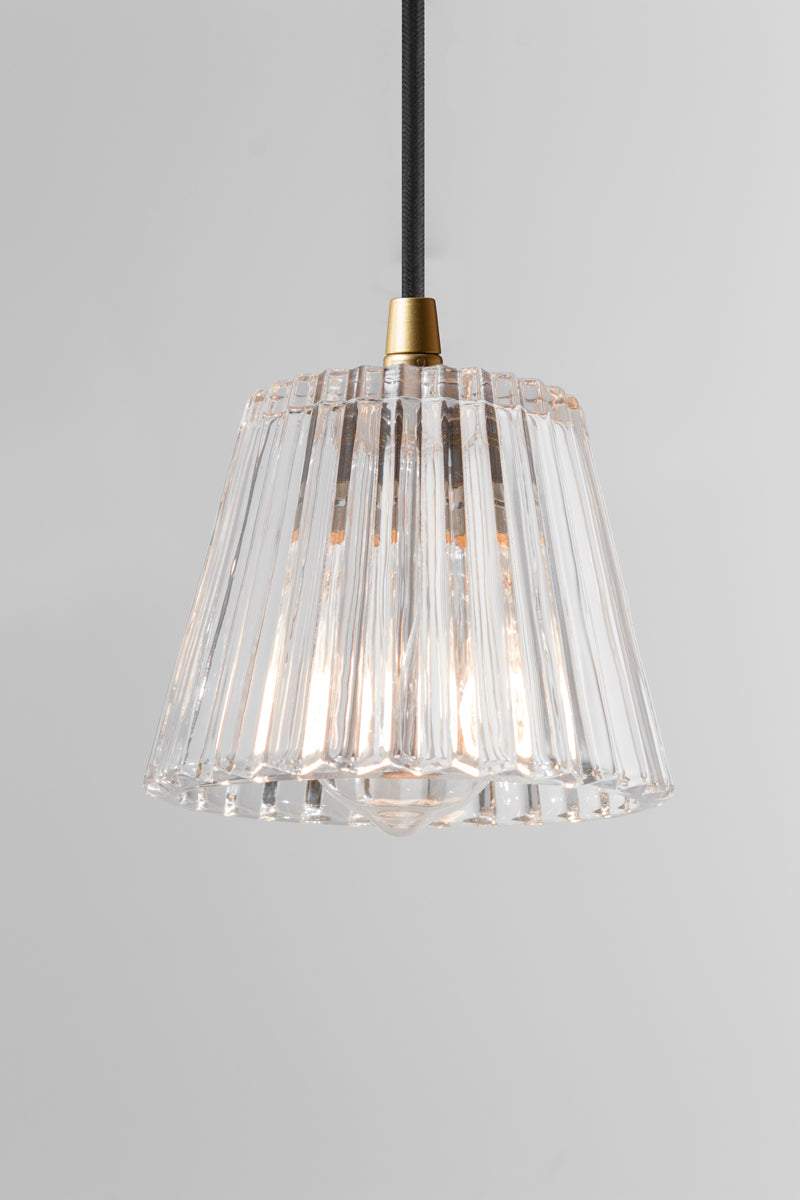 Clear glass pendant light with black gold cord and vertically pressed glass style