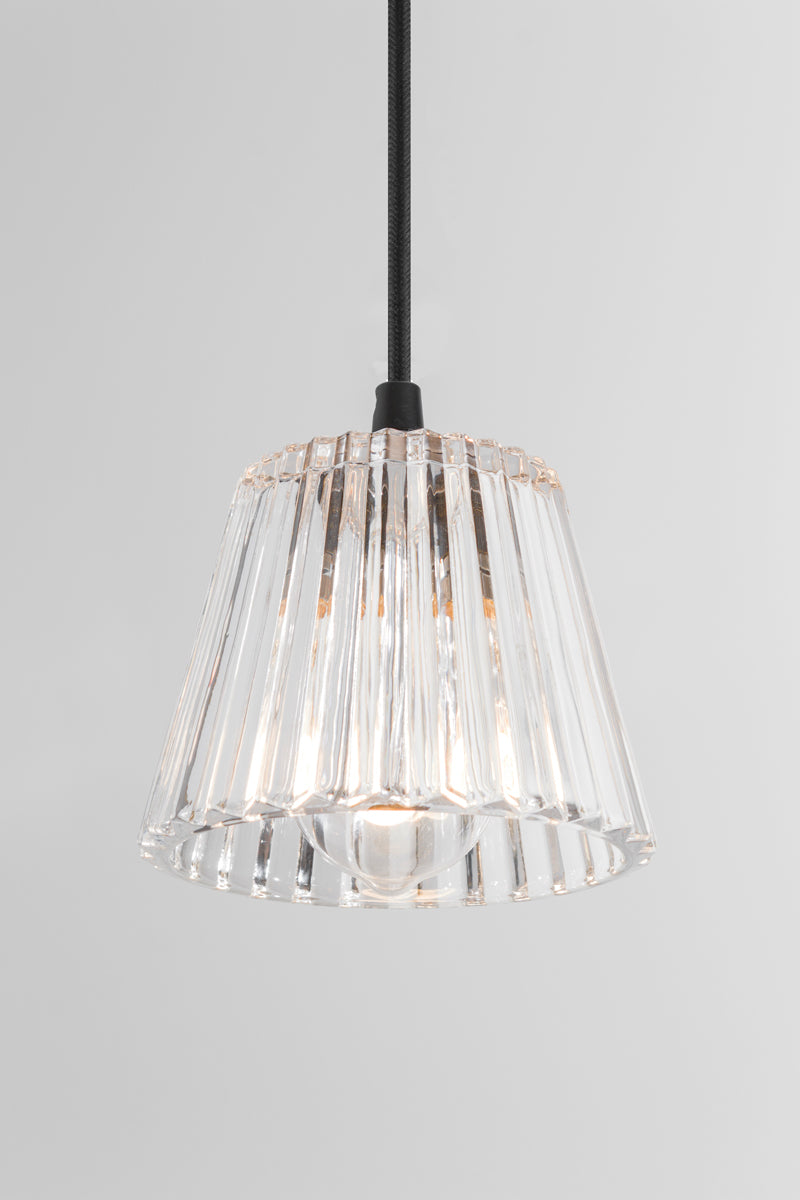 Clear glass with ribbed, faceted detailing softly refracts and diffuses light