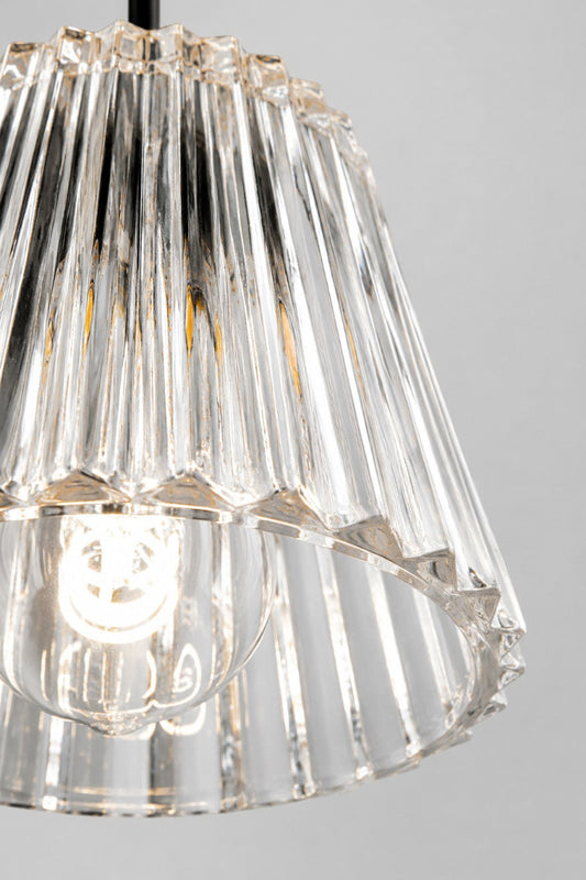 Close-up of the clear fluted glass pendant shade paired with a black lampholder, highlighting the crisp ribbed glass texture and light refraction.
