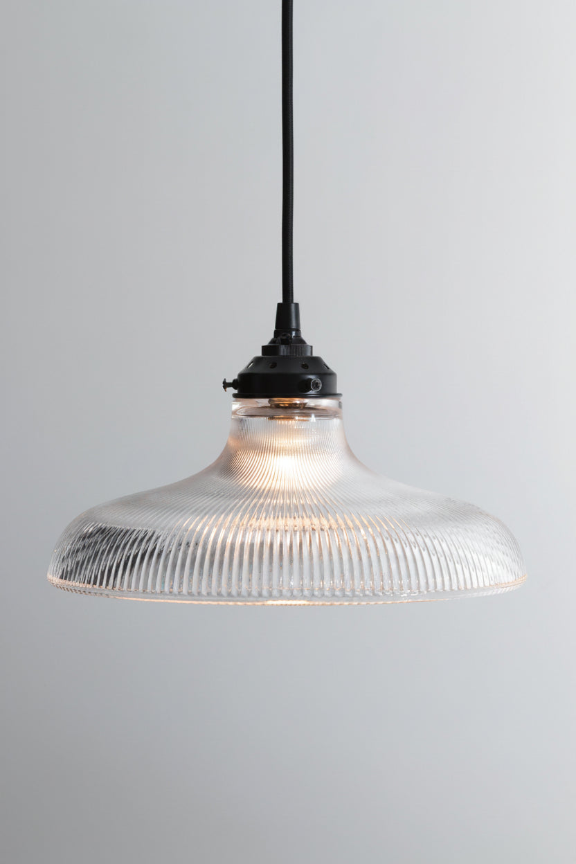Large clear holohpane glass shade on a black braided cloth cord with black hardware. 