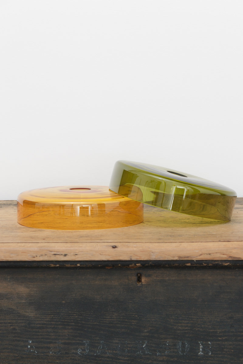 Valla glass shades in amber and green showcased on a timber bench. 