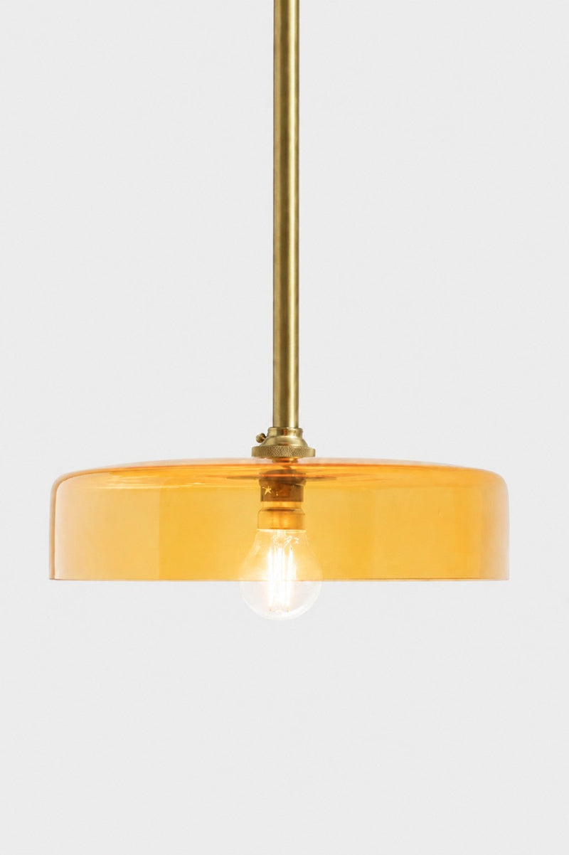 A orange glass shade on gold/brass pole pendant. 