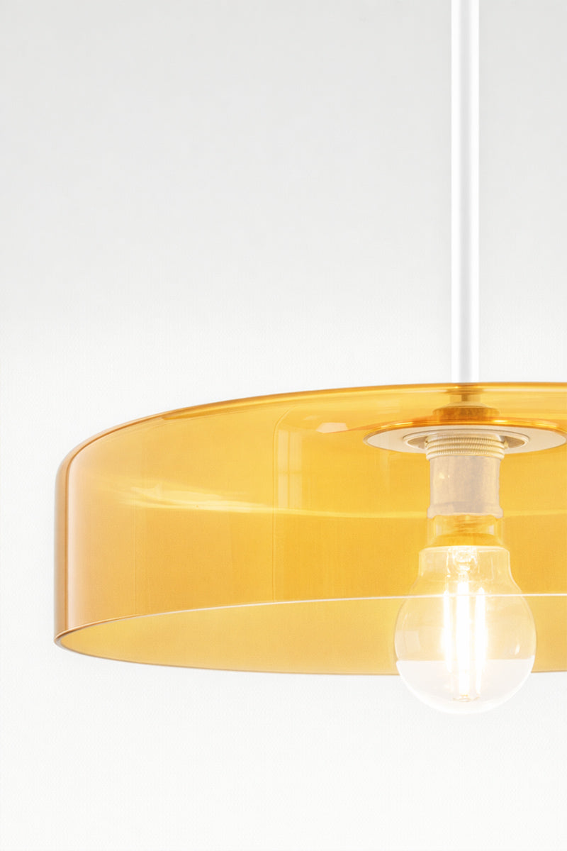 Close up of the amber glass shade on white pole pendant.
