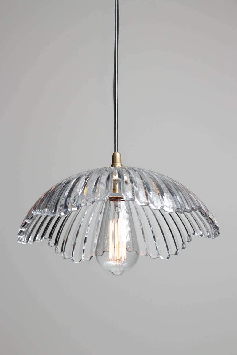 Hepburn Glass Pendant Light with clear fluted glass shade and exposed bulb, suspended from a gold brass lampholder