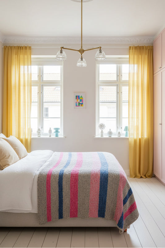 3 arm gold/brass pendant light with clear glass shades in a bright whte bedroom with colourful decor. 
