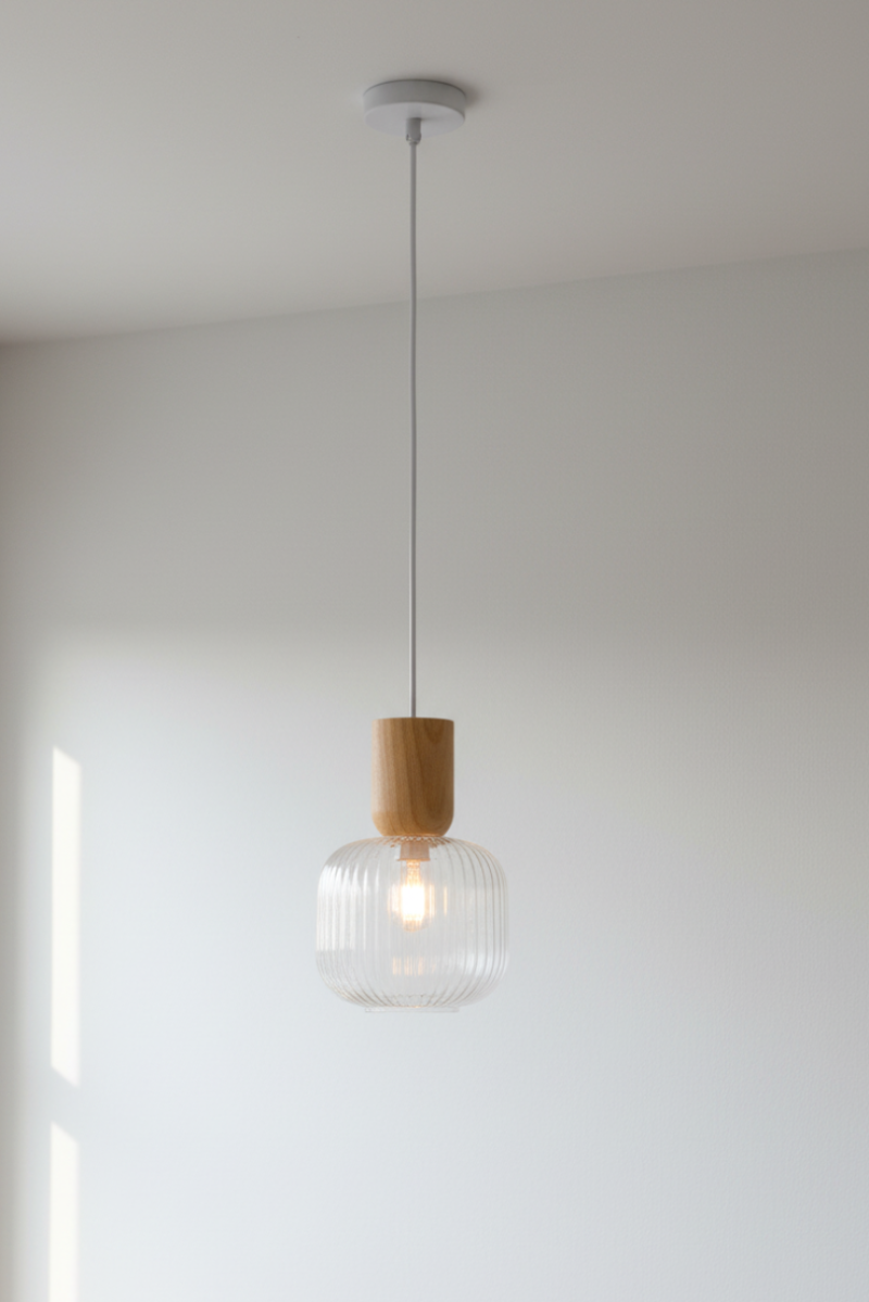 Clear reeded shade paired with pendant cord made out of natural wood, timber.