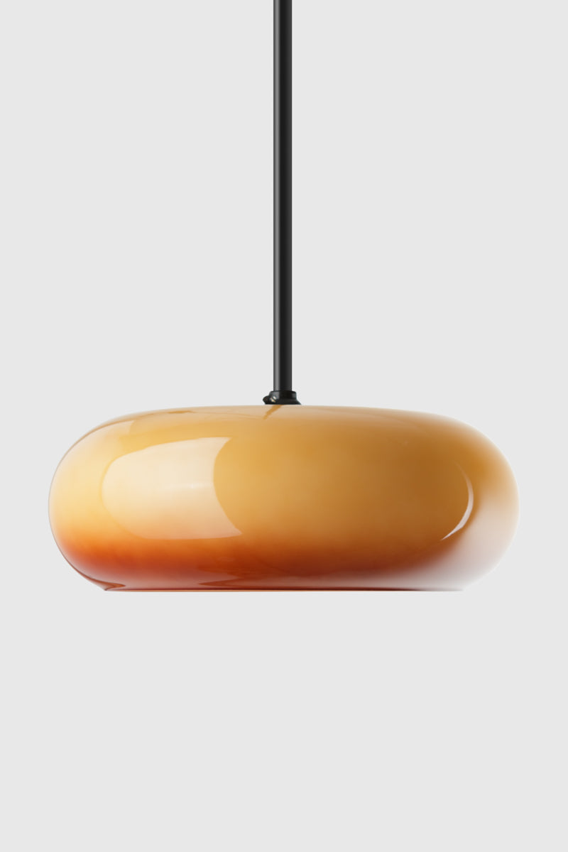 Pendant light with a brown-amber orange glass shade on black pole