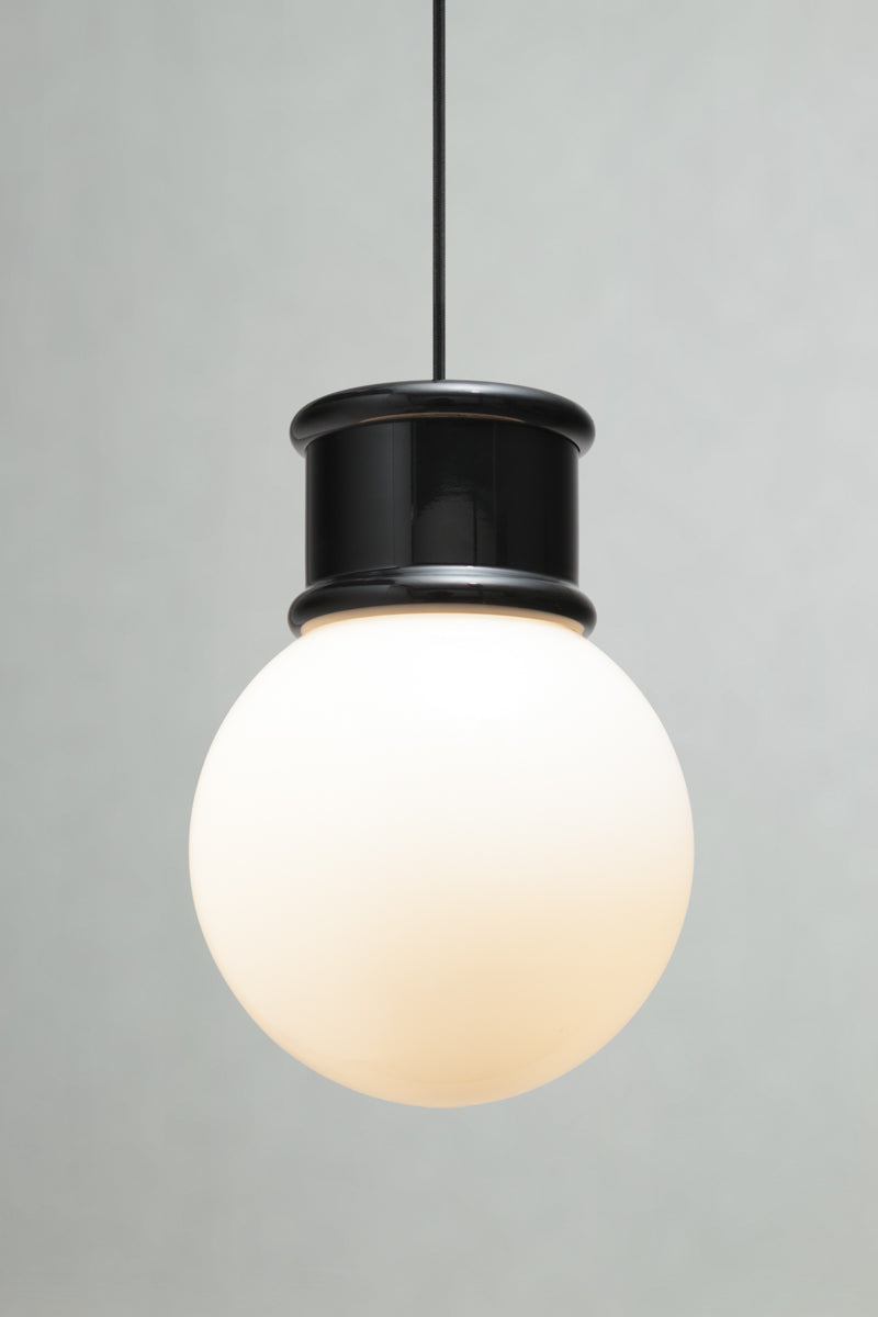 Front view of the medium opal glass ball shade paired with a black topper and pendant cord. 