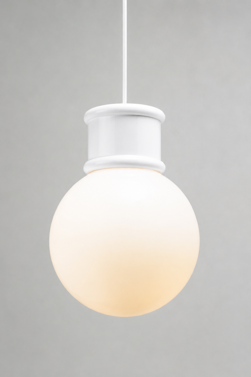 Medium opal glass ball shade paired with a white topper and pendant cord. 