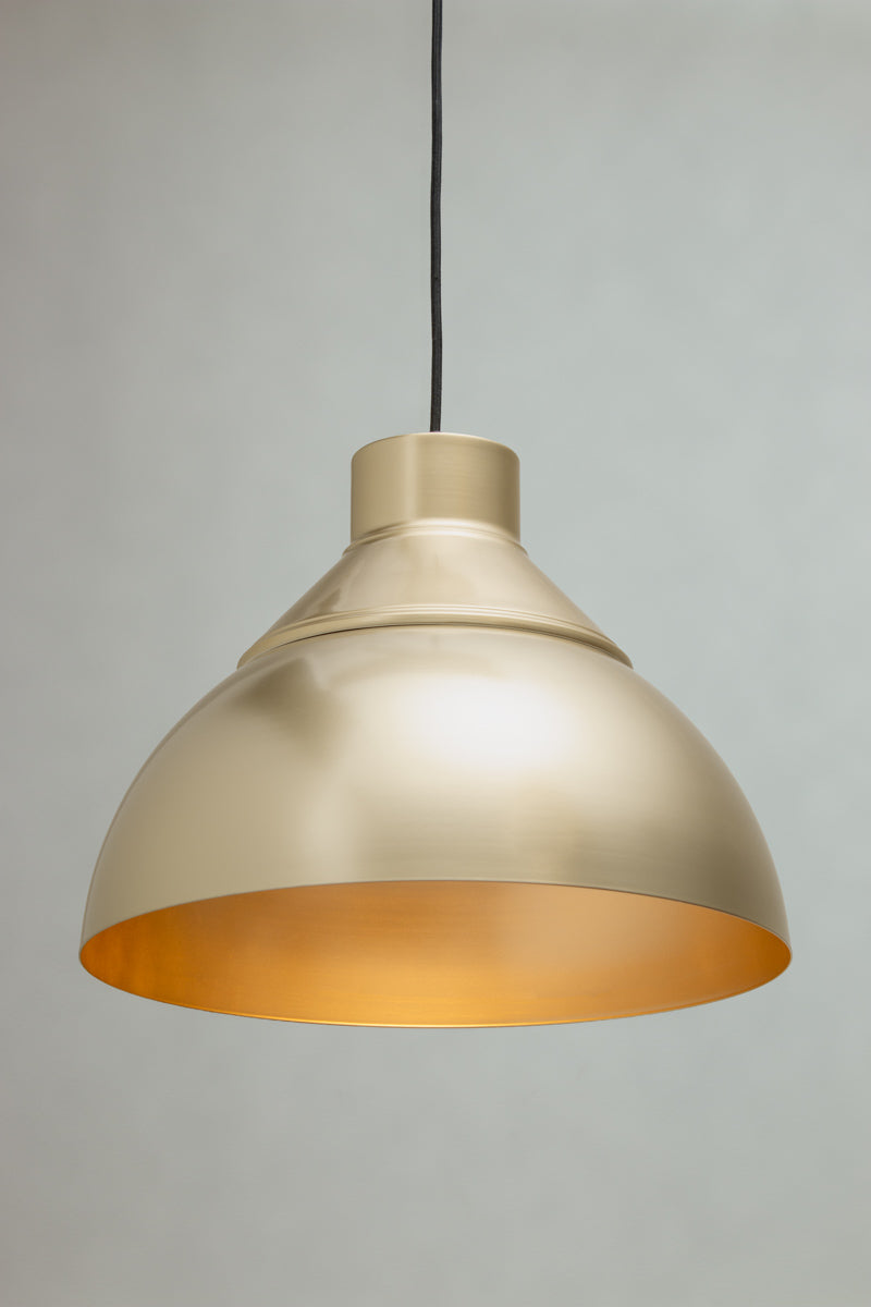 Dome Foundry Pendant Light in brass with warm gold interior and matching metal shade cover