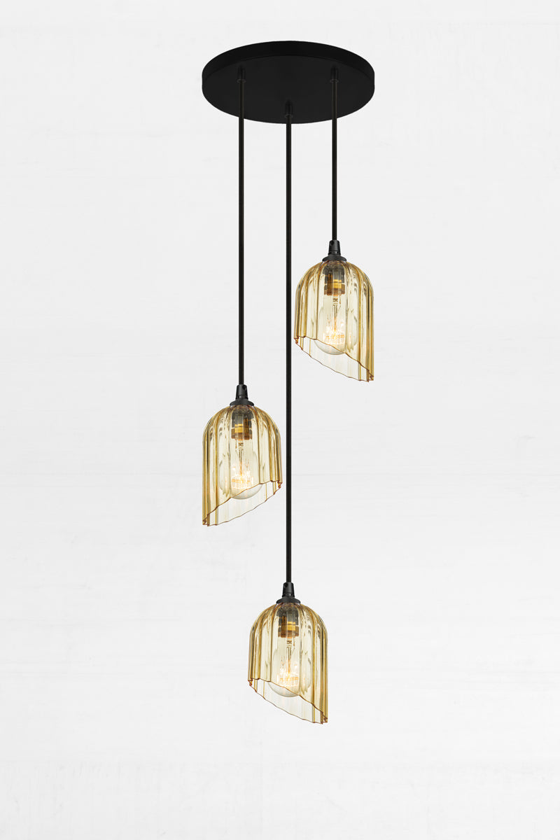Three fluted amber glass shades with an angled cut detail, paired with a black circular ceiling rose and cords. 